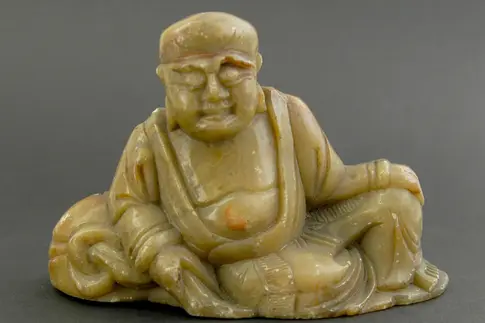 Figur aus Speckstein in Form eines sitzenden Mannes