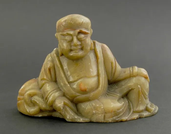 Figur aus Speckstein in Form eines sitzenden Mannes